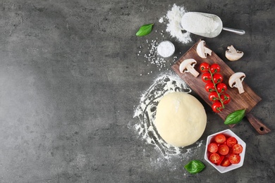 Dough and ingredients for pizza on table, top view