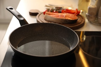 Photo of Frying pan with cooking oil on cooktop