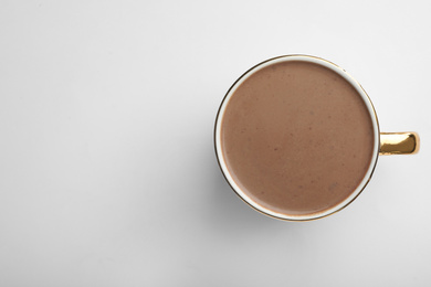 Photo of Delicious cocoa drink in cup on white background, top view