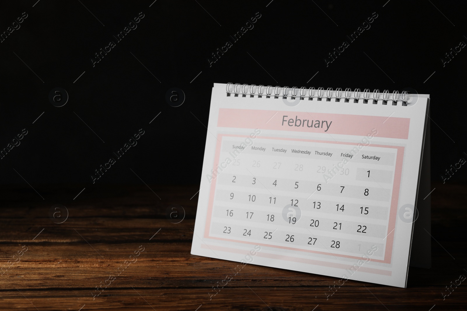 Photo of Paper calendar on wooden table, space for text. Planning concept