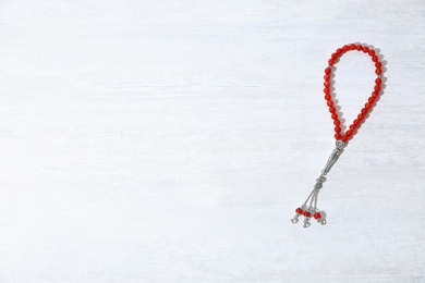 Photo of Muslim prayer beads and space for text on white background, top view