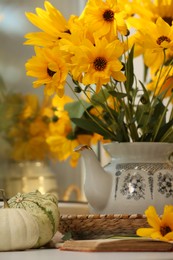 Photo of Composition with beautiful flowers, pumpkins and book on table. Autumn atmosphere