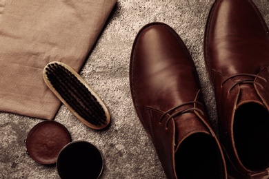 Flat lay composition with shoe care accessories and footwear on stone background