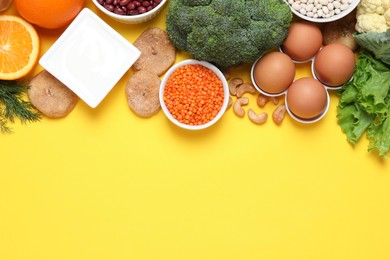 Food high in calcium. Flat lay composition with different products on yellow background, space for text