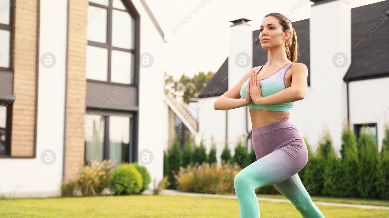 Photo of Woman practicing morning yoga at backyard. Healthy lifestyle