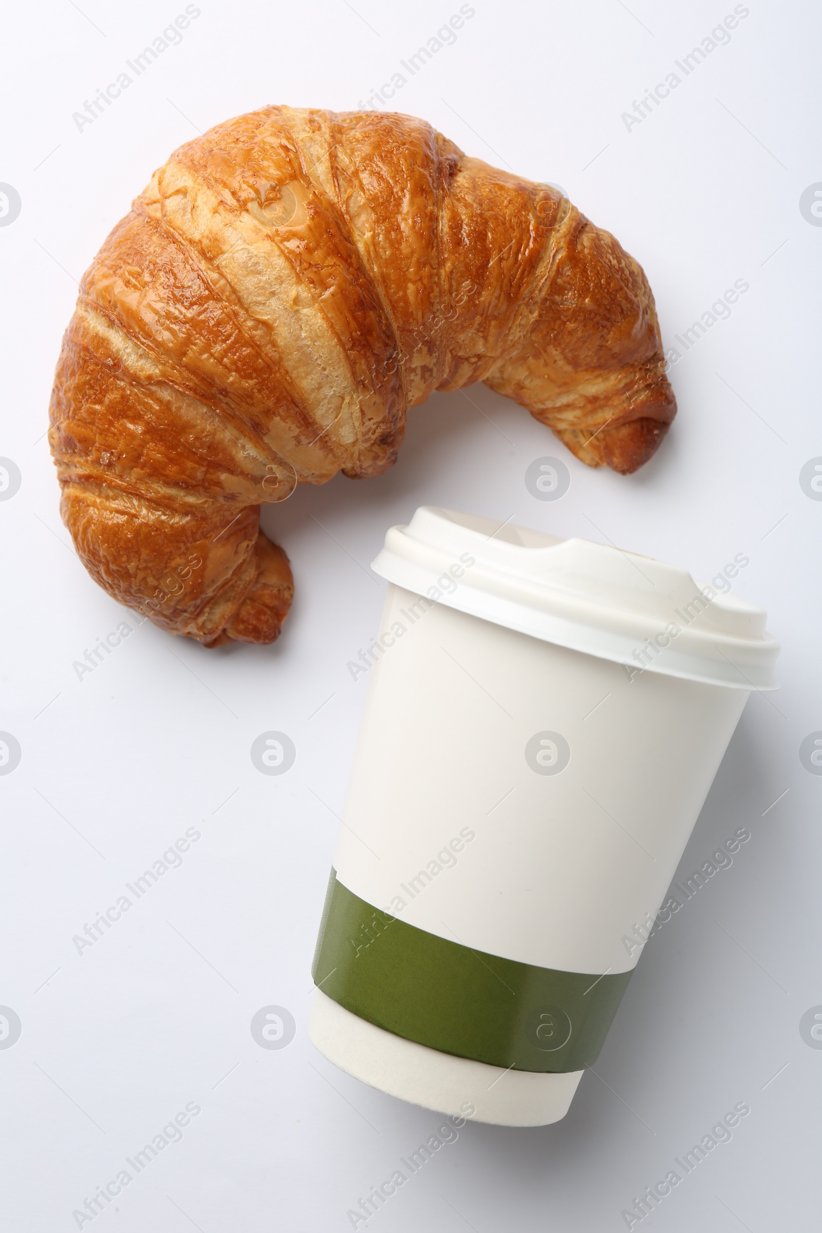 Photo of Delicious fresh croissant and paper cup with coffee on white background, flat lay