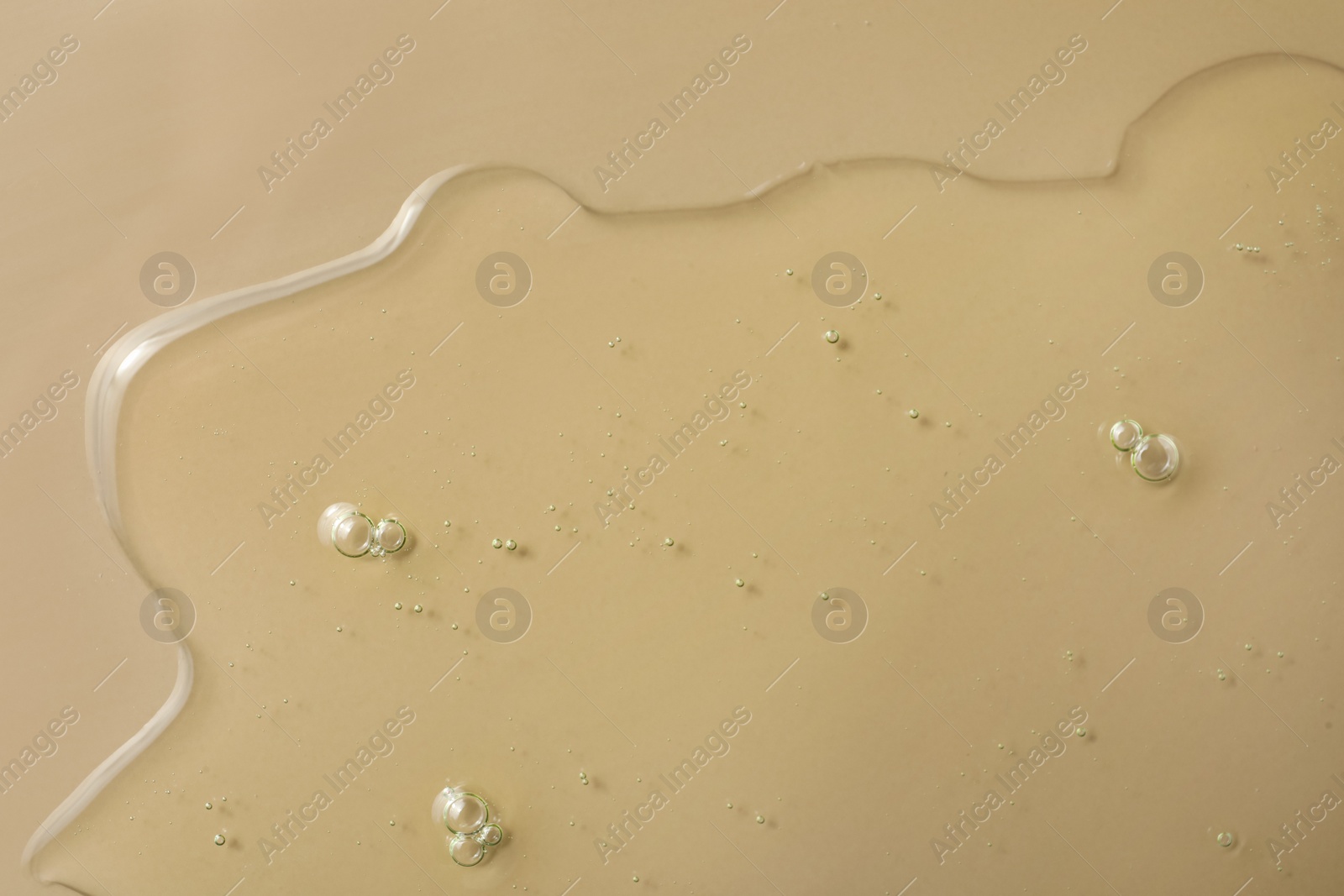 Photo of Sample of hydrophilic oil on beige background, top view