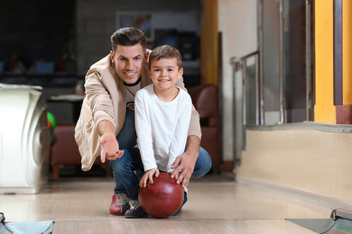 Photo of Father and son spending time together in bowling club