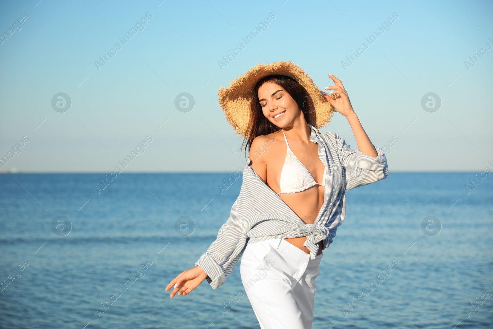 Photo of Beautiful young woman in straw hat on beach