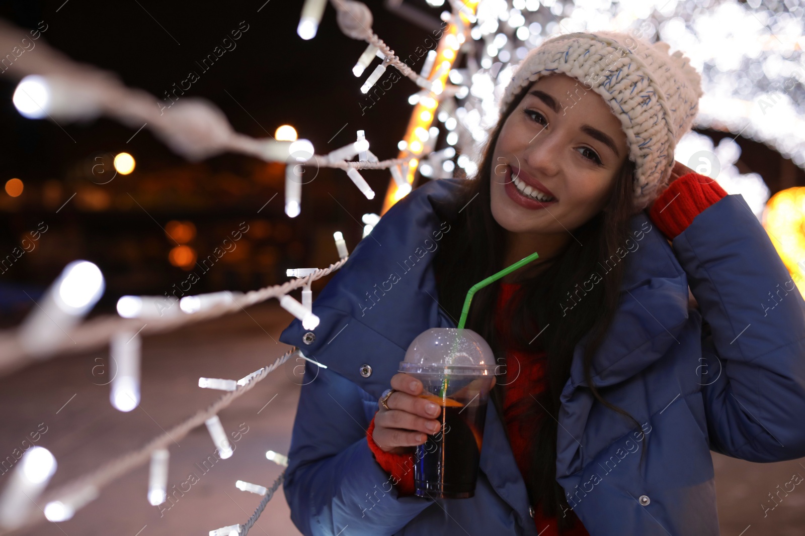 Photo of Woman with cup of mulled wine at winter fair. Space for text