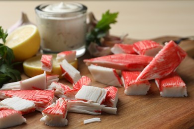 Photo of Delicious crab sticks on wooden board, closeup