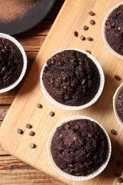 Photo of Tasty chocolate muffins on wooden table, flat lay