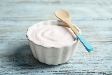 Bowl with tasty yogurt on wooden background