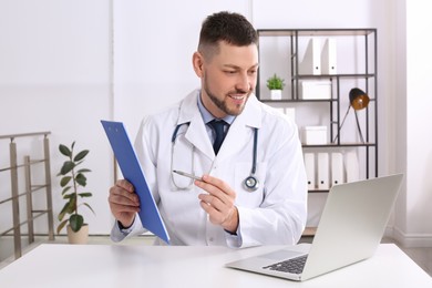 Photo of Pediatrician consulting patient online at desk in office