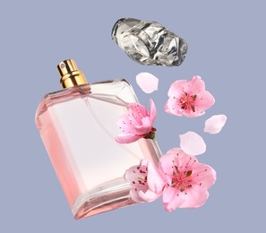 Bottle of perfume and sakura flowers in air on grey background