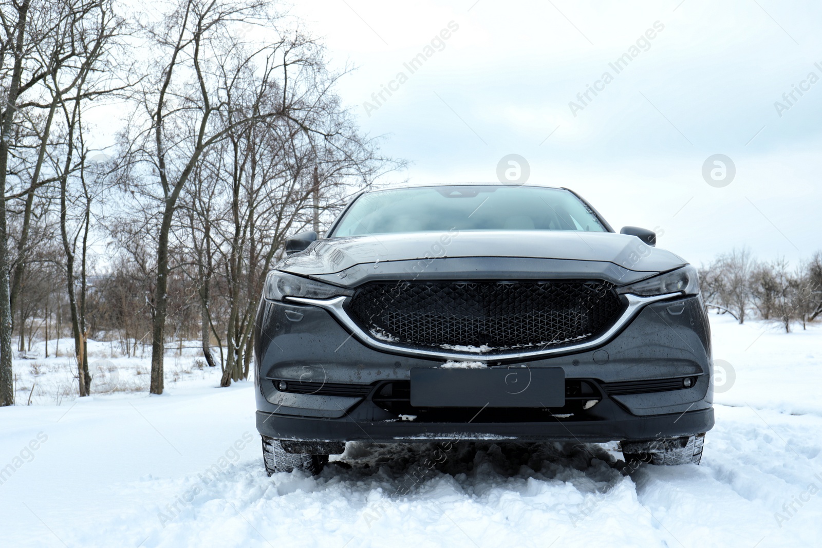 Photo of Snowy country road with car on winter day