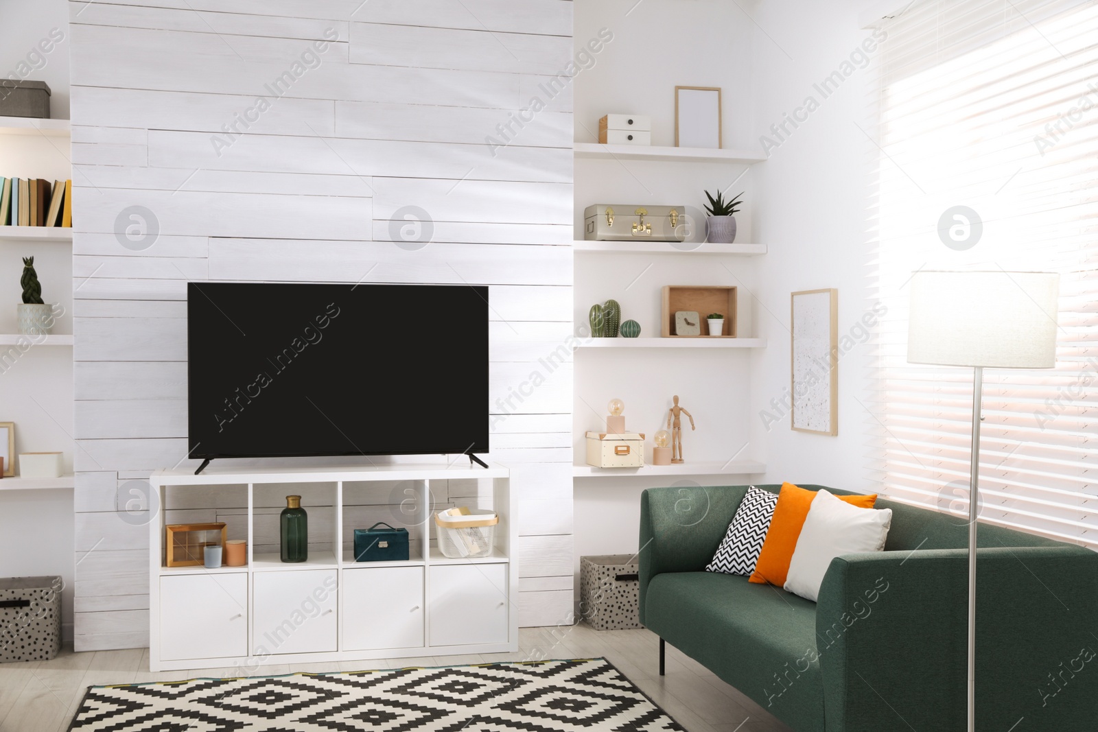 Photo of Cozy room interior with stylish furniture, decor and modern TV set