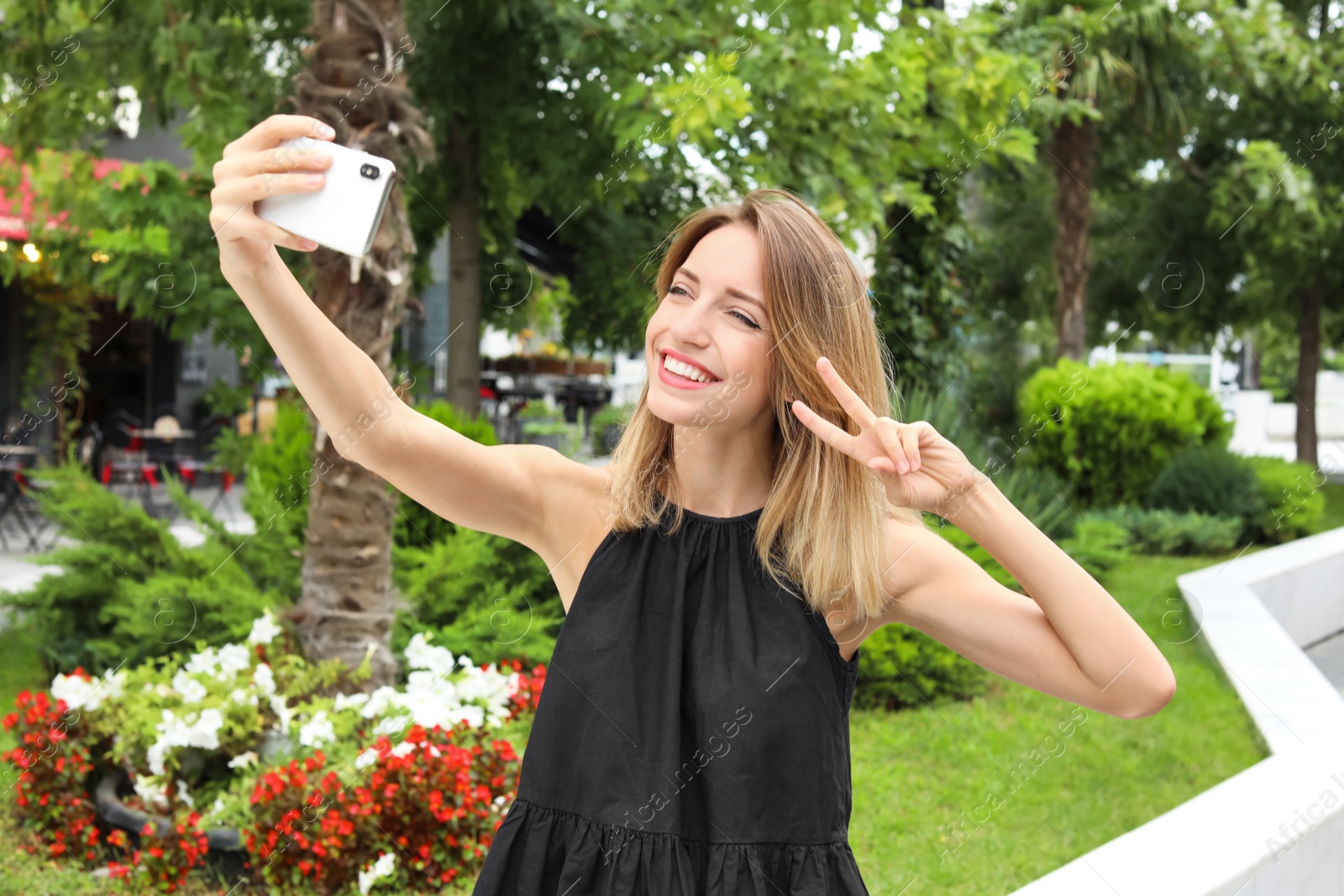 Photo of Attractive woman taking selfie in green park