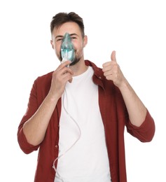Photo of Man using nebulizer for inhalation and showing thumb up on white background
