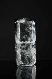 Photo of Blocks of clear ice on black mirror surface