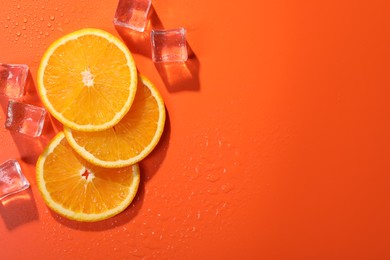 Slices of juicy orange and ice cubes on terracotta background, flat lay. Space for text