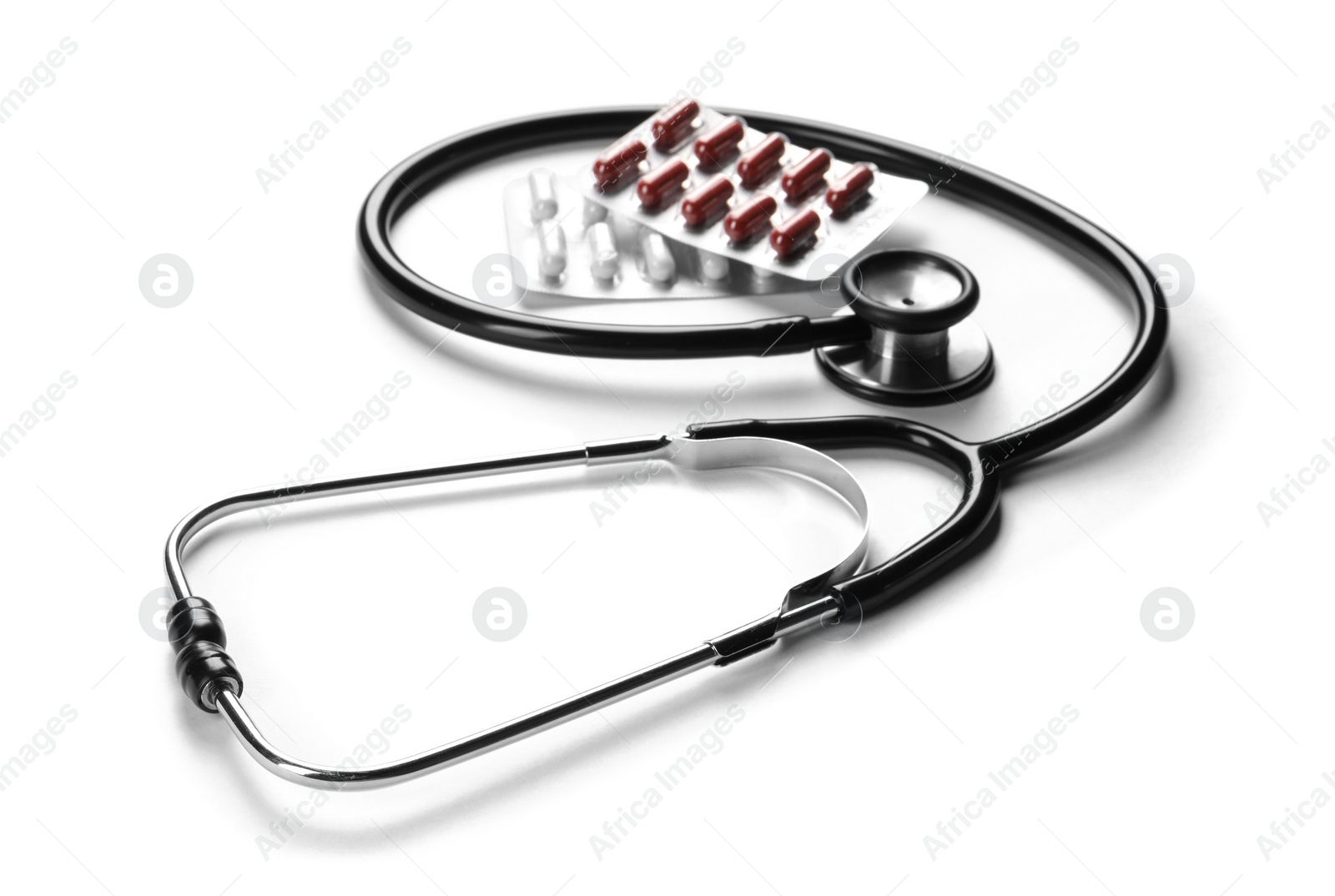 Photo of Stethoscope and different pills on white background