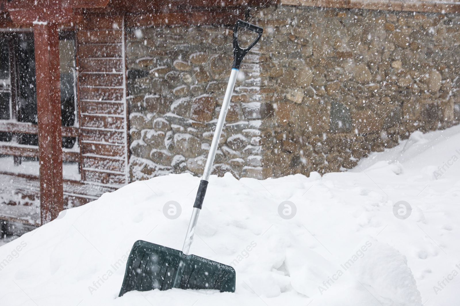 Photo of Snow cleaning shovel near house. Winter outdoor work