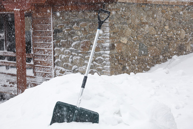 Snow cleaning shovel near house. Winter outdoor work