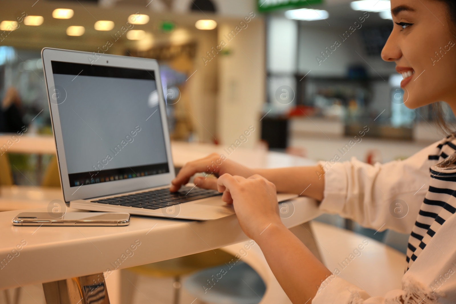 Photo of Blogger working with laptop in cafe, closeup