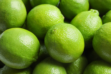 Photo of Fresh ripe green limes as background, closeup view