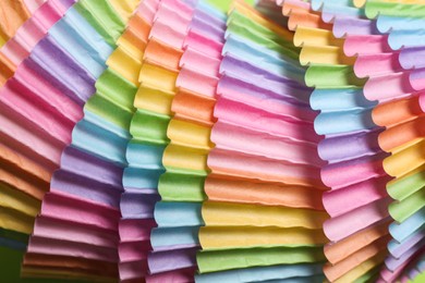Photo of Colorful paper cupcake molds as background, closeup