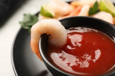 Photo of Tasty boiled shrimps with cocktail sauce, parsley and lime on light grey table, closeup