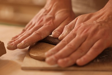Photo of Man crafting with clay at table, closeup