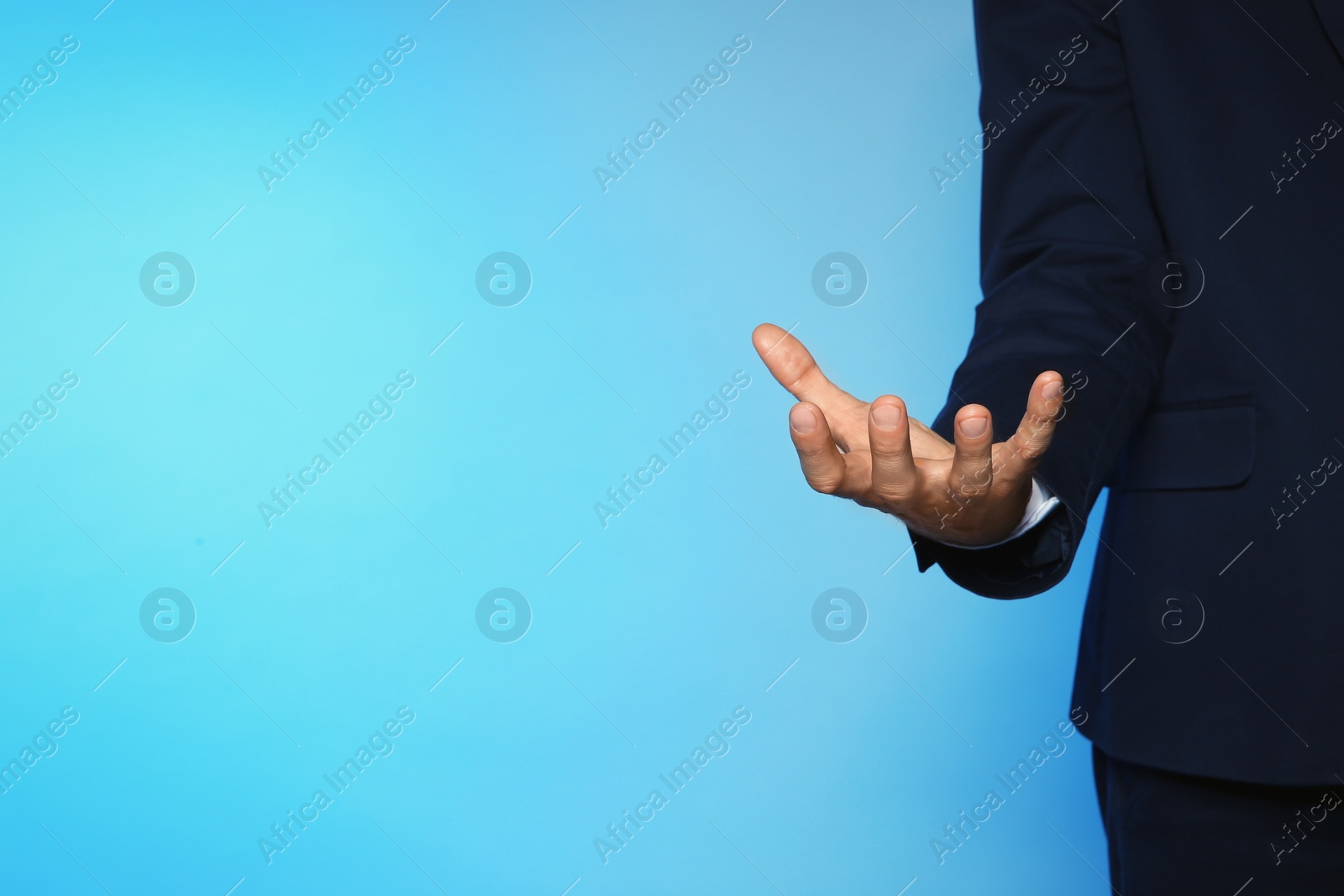 Photo of Businessman holding something on color background, closeup view of hand with space for text