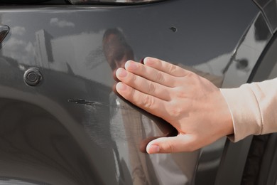 Photo of Man near car with scratch, closeup view