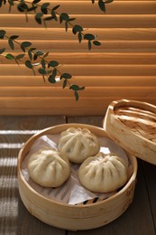 Photo of Delicious bao buns (baozi) on wooden table