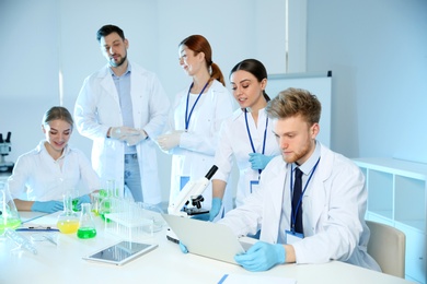 Group of scientists working in modern chemistry laboratory