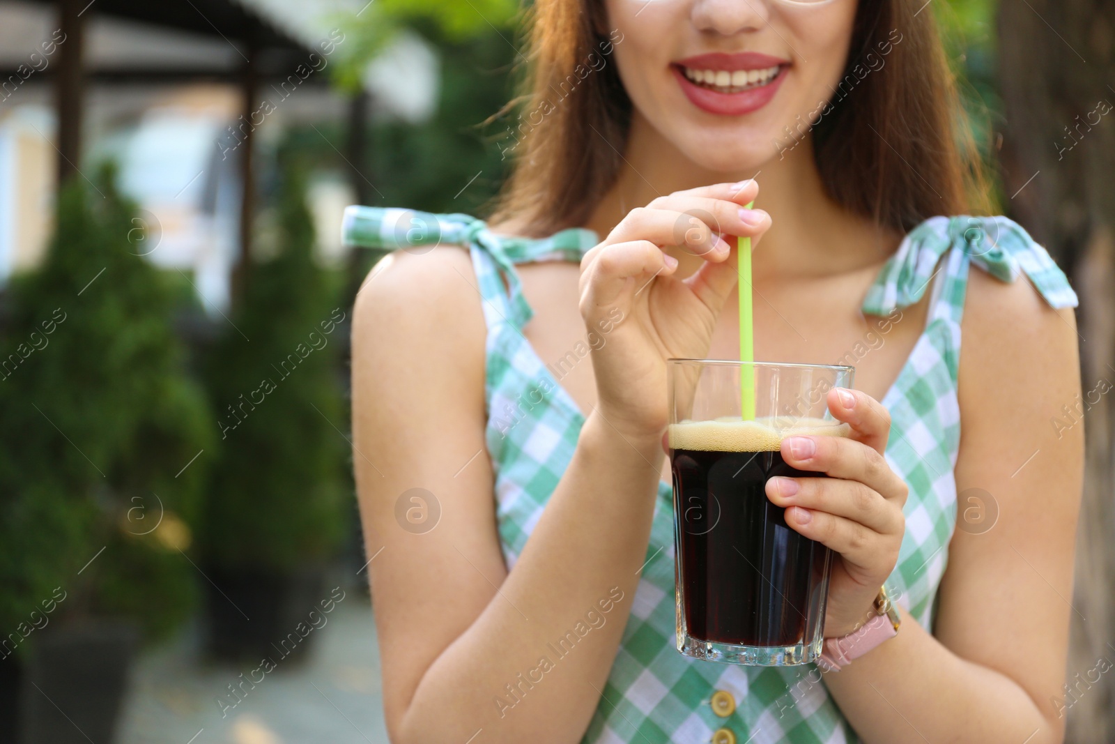 Photo of Young woman with cold kvass outdoors, closeup. Traditional Russian summer drink