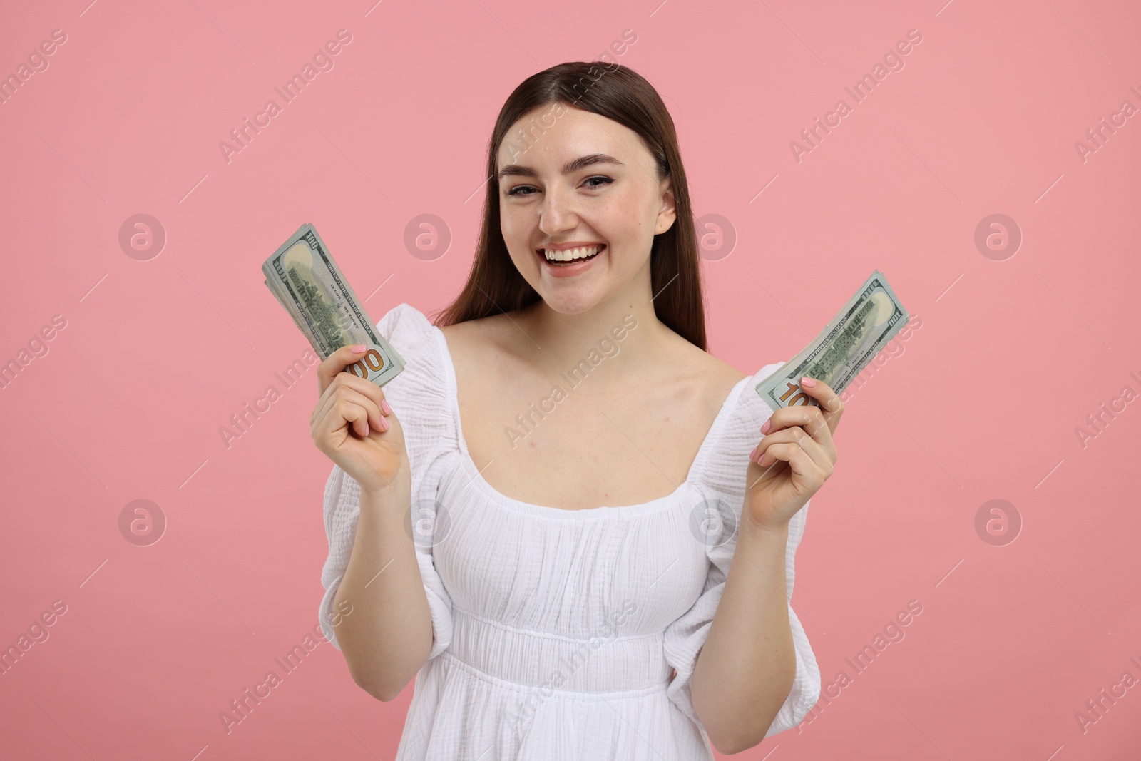 Photo of Happy woman with dollar banknotes on pink background