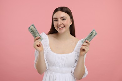 Happy woman with dollar banknotes on pink background