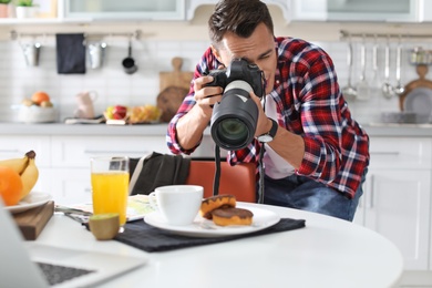 Food blogger taking photo of breakfast in kitchen