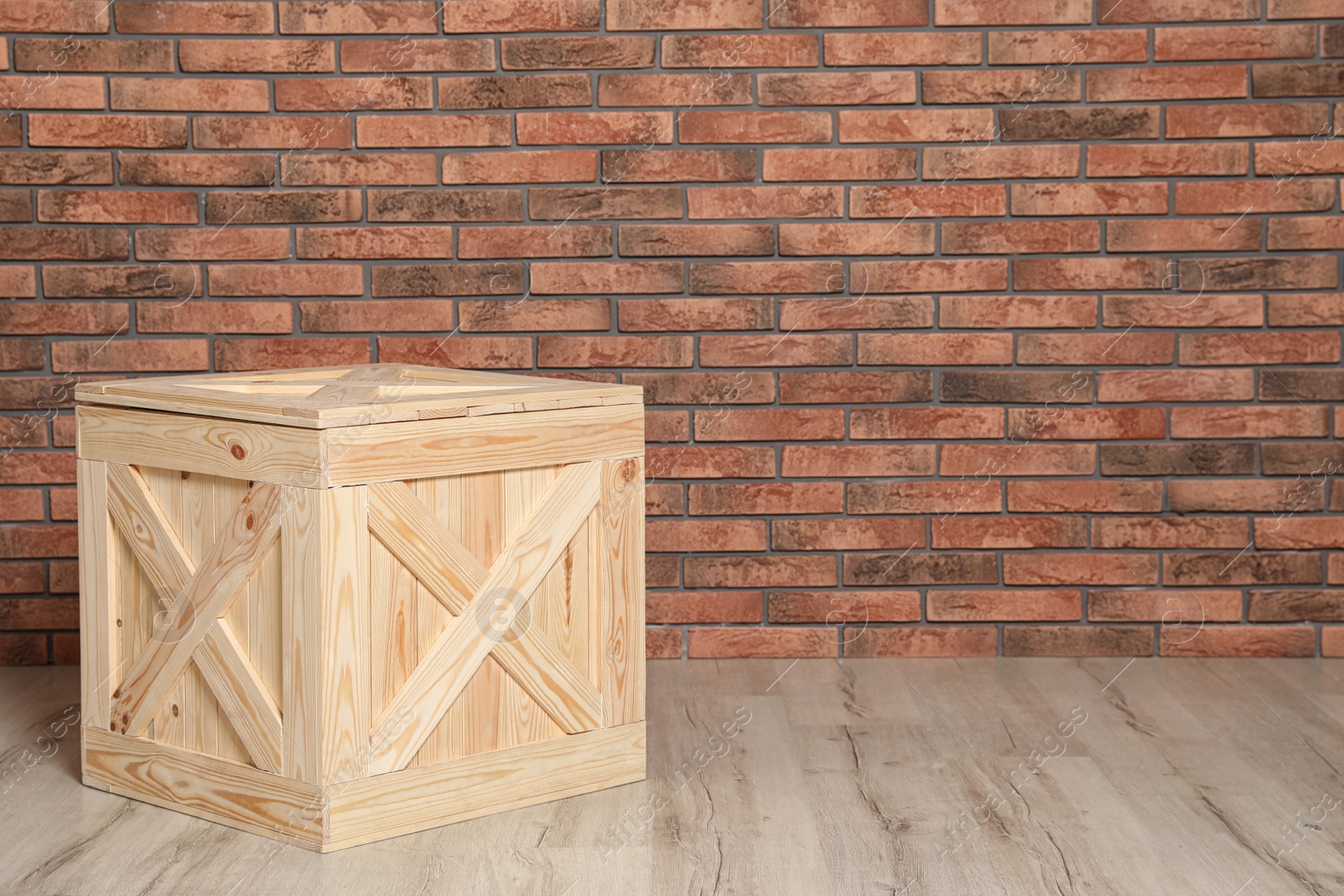 Photo of Wooden crate on floor at brick wall. Space for text