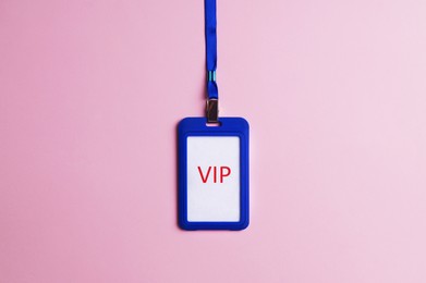 Photo of Plastic vip badge on pale pink background, top view