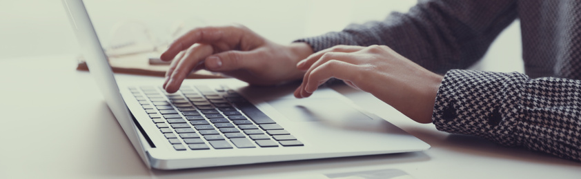 Image of Young woman working on computer at table indoors, closeup. Banner design