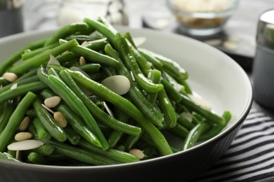 Photo of Bowl of tasty salad with green beans on table, closeup view