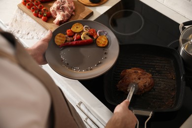 Photo of Man taking cooked meat from frying pan, above view