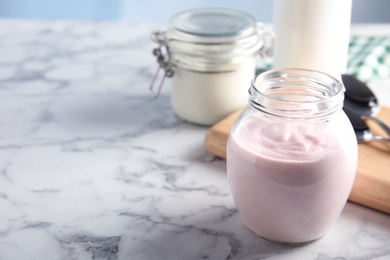 Photo of Glass jar of fresh yogurt on table. Space for text