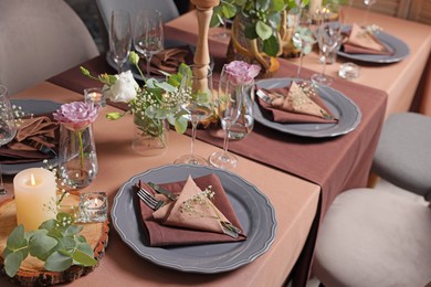 Elegant table setting with beautiful floral decor and burning candles