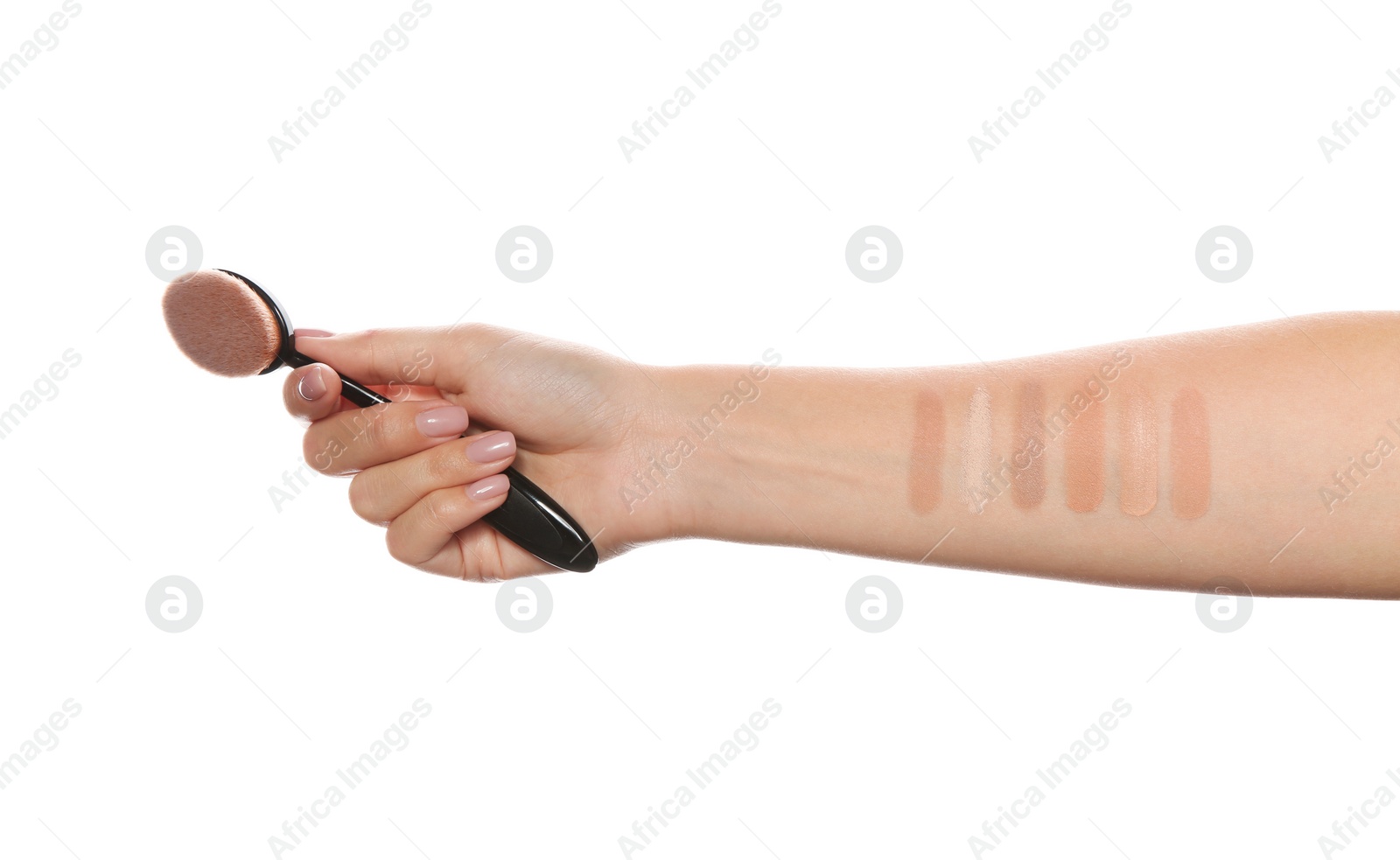 Photo of Woman testing different shades of liquid foundation on her hand against white background, closeup