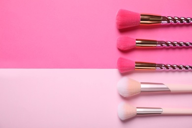 Photo of Different makeup brushes on color background, flat lay. Space for text